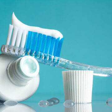 New toothbrush with toothpaste close-up in the bathroom on a mirror table with water drops on a blue background in the sunlight