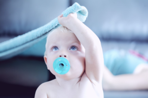 baby with blue blanket and pacifier