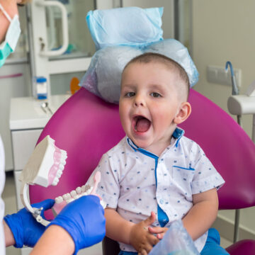 Little boy showing his teeth to a doctor
