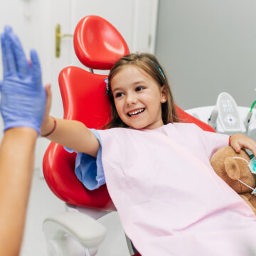 Little girl smiling in dental chair during checkup